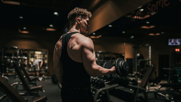 a man holding a dumbbell in a gym